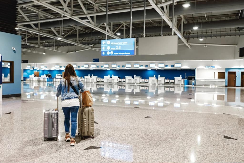 A traveler with luggage passing through an airport transit terminal secured by Gatestile entrance gates